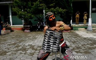 Petugas SPPG Danupayan memakai kostum warok saat mengantar MBG ke sekolah